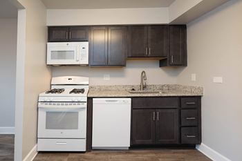 Kitchen with dark cabinets and white appliances